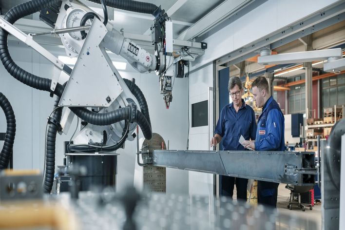 Zwei Männer an Laserschweißmaschine.