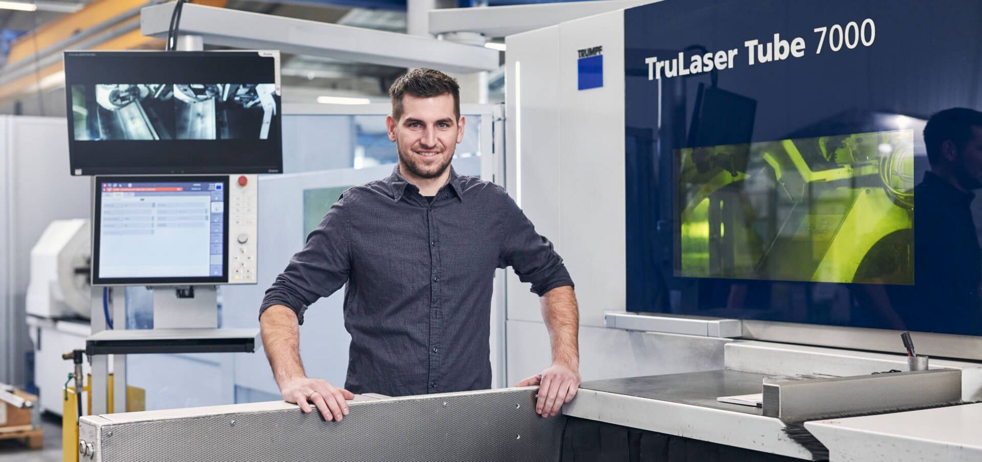 Mann steht an TruLaser Tube Maschine