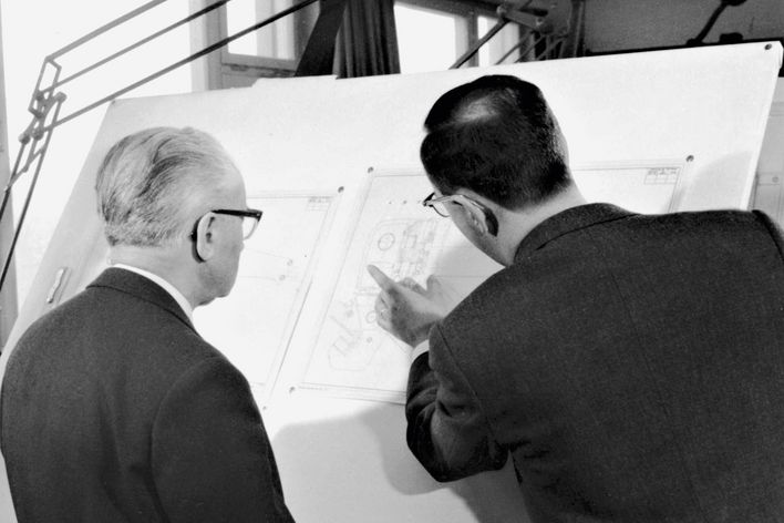 historical picture showing Berthold Leibinger explaning an engineering drawing