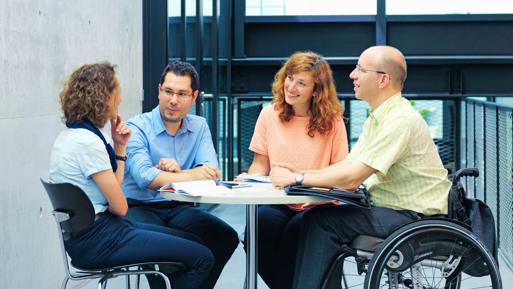 TRUMPF employees talking Amongst the group is a disabled employee