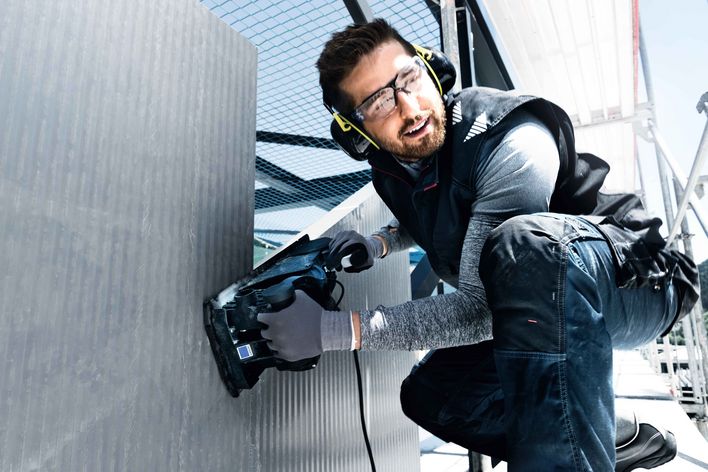 Man with PPE (glasses, gloves, ear protectors)