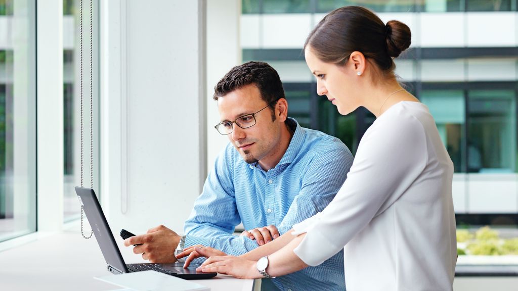 TRUMPF employees talking and working together with a laptop