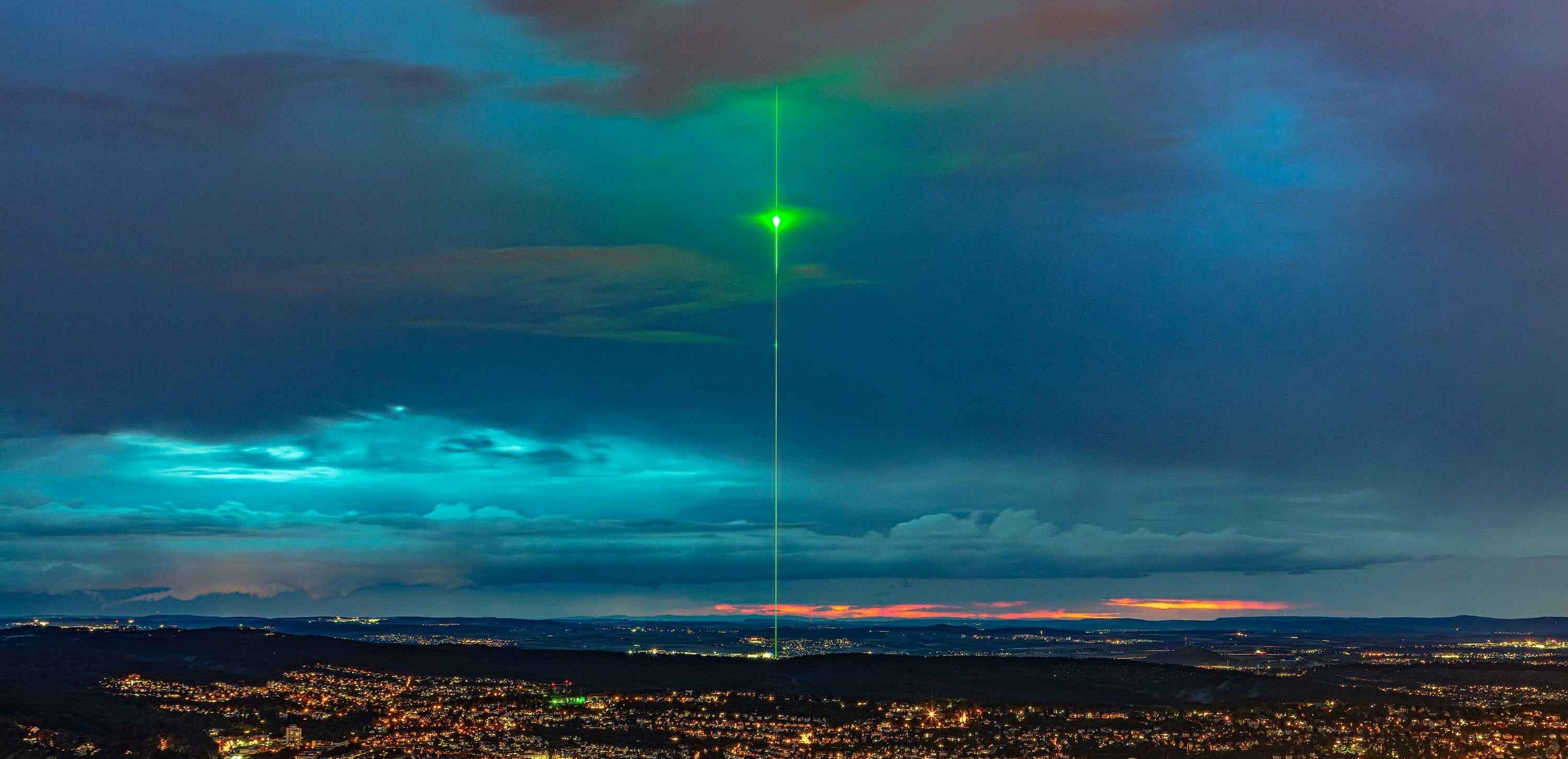 Green show laser towers into the sky above the TRUMPF plant in Ditzingen